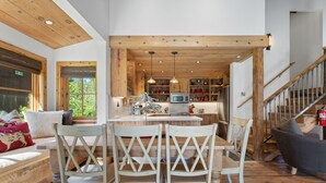 A spacious kitchen with wooden beams, a central island, and pendant lighting. - A Serene Mountain Autumn/Fall Getaway (Soda Springs)