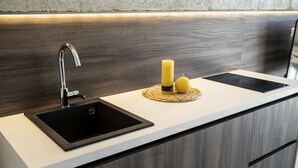 Une cuisine moderne avec un robinet élégant, un évier noir et un plan de travail en bois.