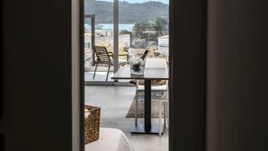 Un balcon avec une table et des chaises, un panier en osier et une vue sur un paysage montagneux.