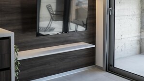 Une salle de bain moderne avec un mur d’accent en béton, un banc intégré et un grand miroir.