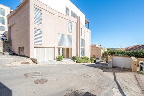A modern two-story building with a flat roof, large windows, and a gated driveway. - Attico Salia - La Maddalena (La maddalena)