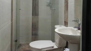 A small bathroom with a toilet, a sink, and a glass-enclosed shower. - Nice and Comfortable Apartment on second floor#202 (Dosquebradas)