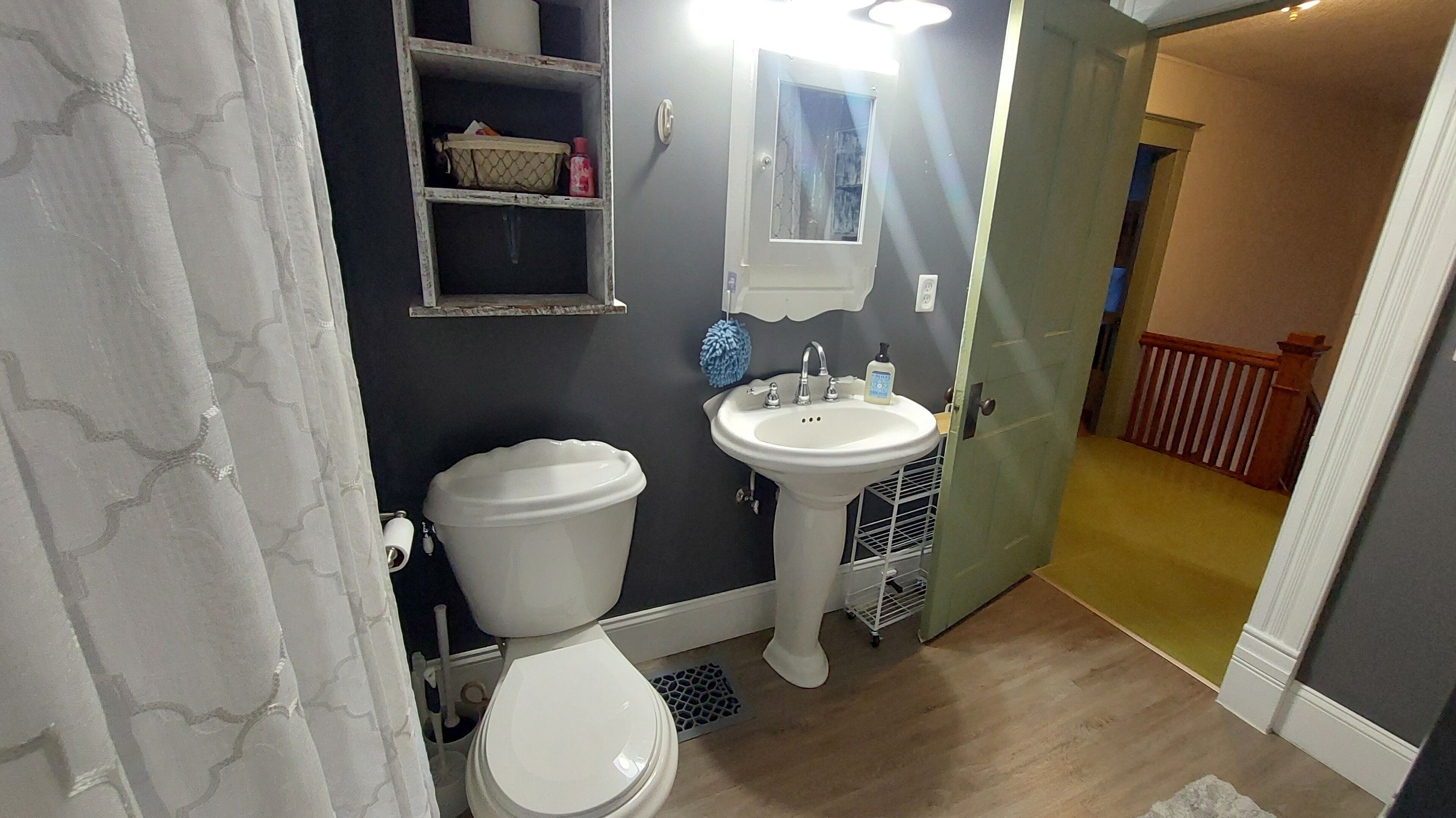Un baño con inodoro, lavamanos y cortina de ducha.