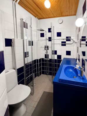 A bathroom with a shower, toilet, and sink. - Stylish Historic Studio in the Heart of Helsinki (Helsinki)