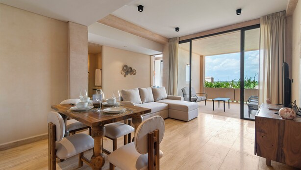 Una sala de estar moderna con comedor, un sofá y un balcón con vistas.