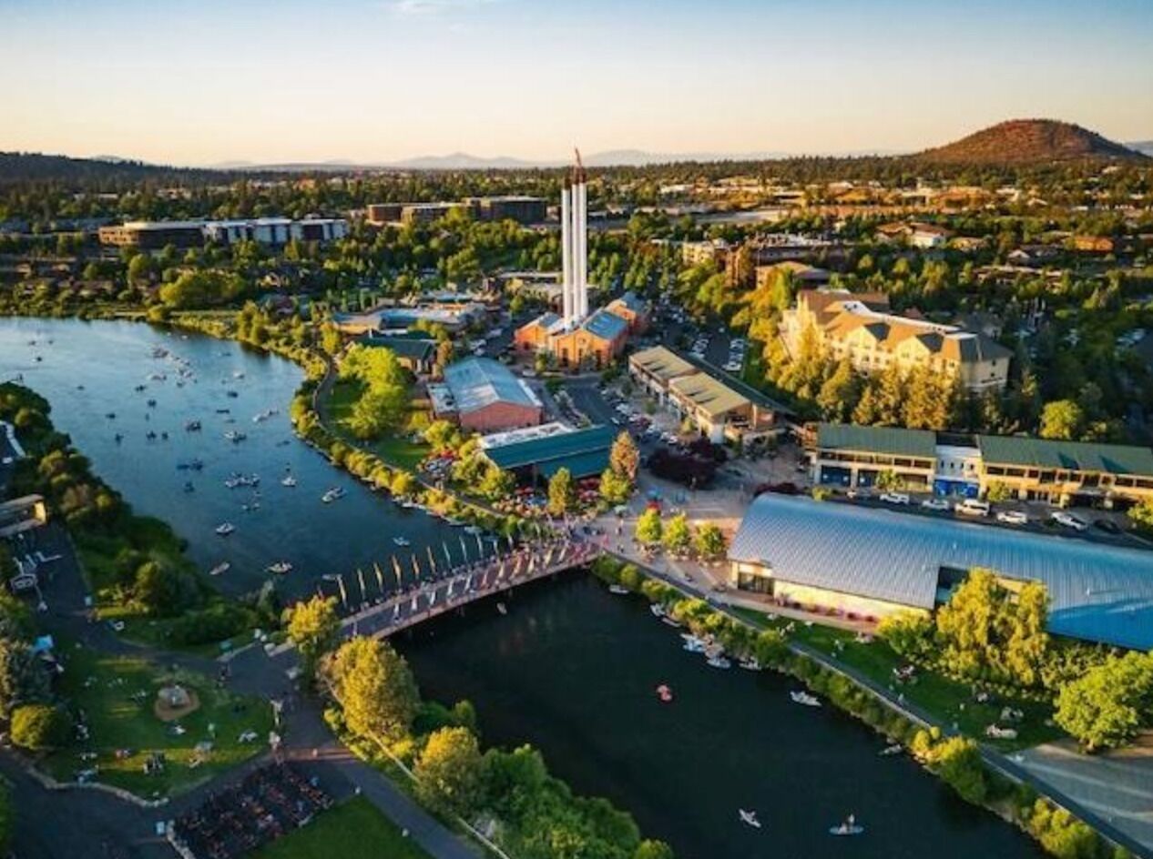 Vista aérea de un campus con un río, edificios y un puente.