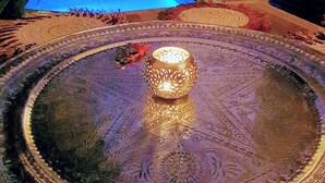 A pool area with a decorative fountain and a patterned rug.