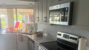 A modern kitchen with stainless steel appliances, a microwave, and a stove. - 3 bedroom Amazing cool house with tons of character! (Port Charlotte)