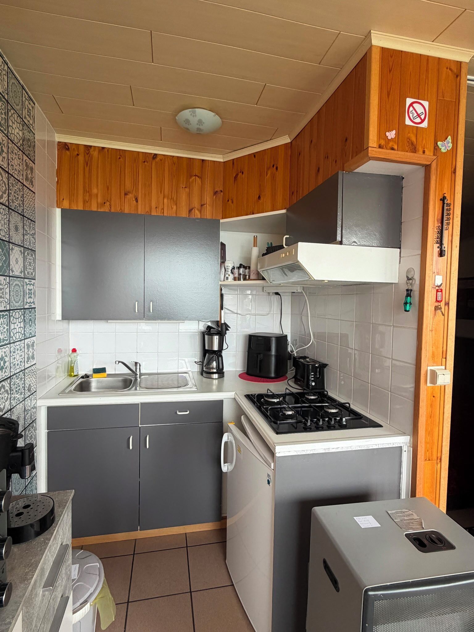 Een koffiezetapparaat/waterkoker, een koelkast, een oven, een kookplaat