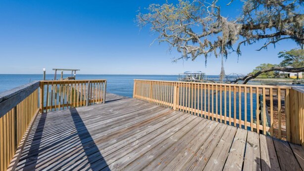 A wooden deck with a railing overlooking a body of water. - Bay Leave | Perfect coastal getaway! (Gulf Shores)