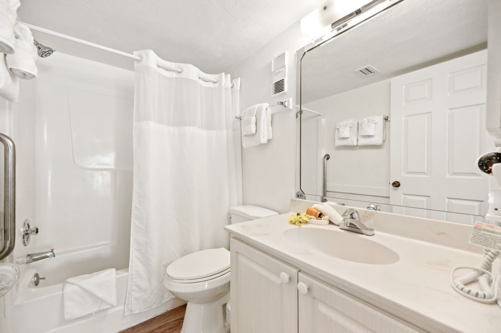A bathroom with a bathtub, toilet, and sink.