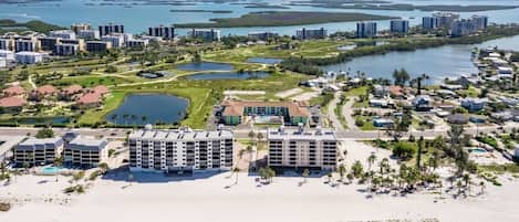 Um resort costeiro com vários edifícios altos, uma praia e um porto de iates.