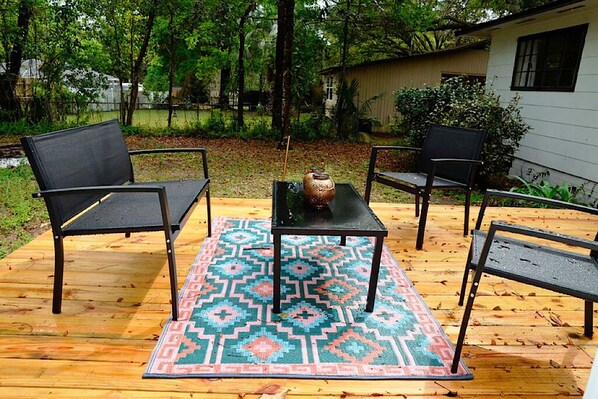 An outdoor patio with a patterned rug, two chairs, and a table. - Charming Getaway near the Square! (Ocala)