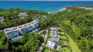 Luchtbeeld van een resort met meerdere gebouwen, een golfbaan en een strand.