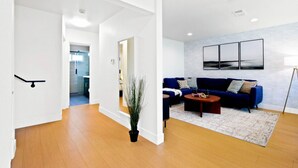 Un salon moderne avec un canapé bleu, une table basse et une plante en pot.