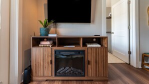 Eine Holz-Multifunktionsmöbel mit Fernseher, Büchern und Dekorationselementen.