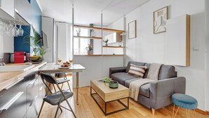 A modern living space with a kitchen, dining area, and seating area. - Cozy 1BR in Montorgueil (Paris)