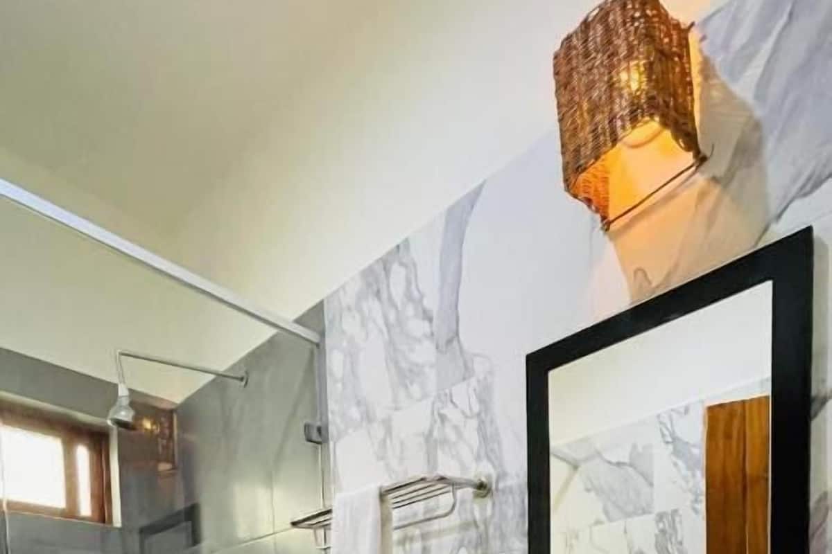 Tina con regadera, toallas, jabón, shampoo