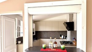 A kitchen with a countertop, a red mat, and bottles of alcohol.