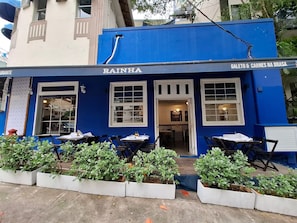 Un restaurant appelé « RAINHA », doté d’une terrasse et d’une façade bleue.