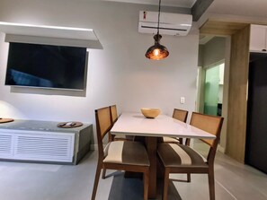 A dining area with a white table, wooden chairs, a bowl, and a pendant light. - Leblon- Design e aconchego.  (Rio de Janeiro)