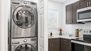 A modern kitchen with stainless steel appliances, wooden cabinets, and a built-in oven. - Mojitos - Springfield Brand NEW Apt! (Jacksonville)