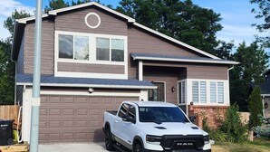 A residential house with a garage, a driveway, and a parked pickup truck. - Family Retreat, Fire Pit • EV Charger • Near Denver • Sleeps 9 (Arvada)