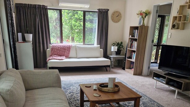 Una sala de estar con sofá, mesa de centro y televisor.
