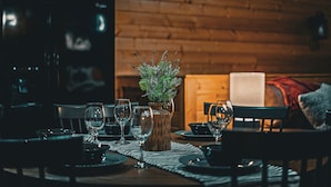 Tavola imbandita con piatti, bicchieri e un vaso decorativo con piante.