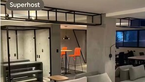 A modern interior with a sofa, tables, and chairs.