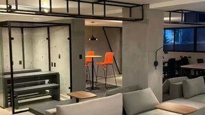 A modern interior with a sofa, tables, and chairs. - Beachfront apartment in Bessa (João Pessoa)