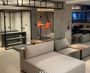 A modern interior with a sofa, tables, and chairs.
