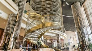 A spacious lobby with a central spiral staircase, comfortable seating, and a modern chandelier. - Cozy 1-bedroom apartment in Business Bay, Downtown (Dubai)