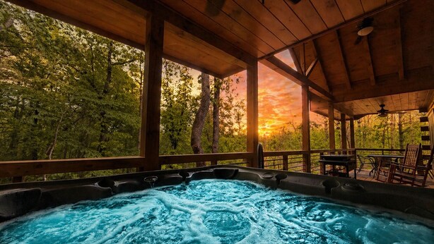 A hot tub with a view of a sunset through a wooden deck. - Romantic Log Cabin • Hot Tub + Vinyl Records • 15 Min to Ellijay (Ellijay)