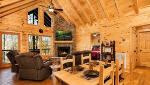 A wooden cabin interior with a fireplace, television, and seating area. - Romantic Log Cabin • Hot Tub + Vinyl Records • 15 Min to Ellijay (Ellijay)
