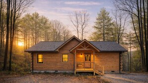 A log cabin with a porch, windows, and a door, surrounded by trees. - Romantic Log Cabin • Hot Tub + Vinyl Records • 15 Min to Ellijay (Ellijay)