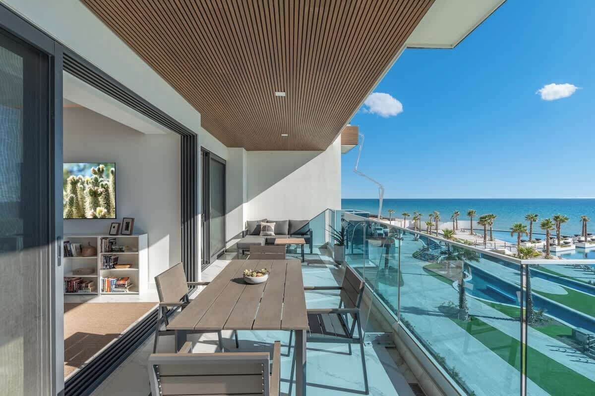 Un balcone moderno con piscina e vista sul mare.