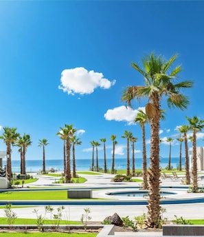 Ein Resort mit Palmen, einem Pool und Blick auf den Ozean.