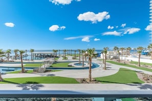 Ein Resort mit mehreren Swimmingpools, Palmen und blauem Himmel.
