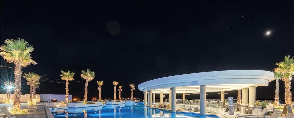 Ein Poolbereich mit Liegestühlen und einer überdachten Sitzgelegenheit.