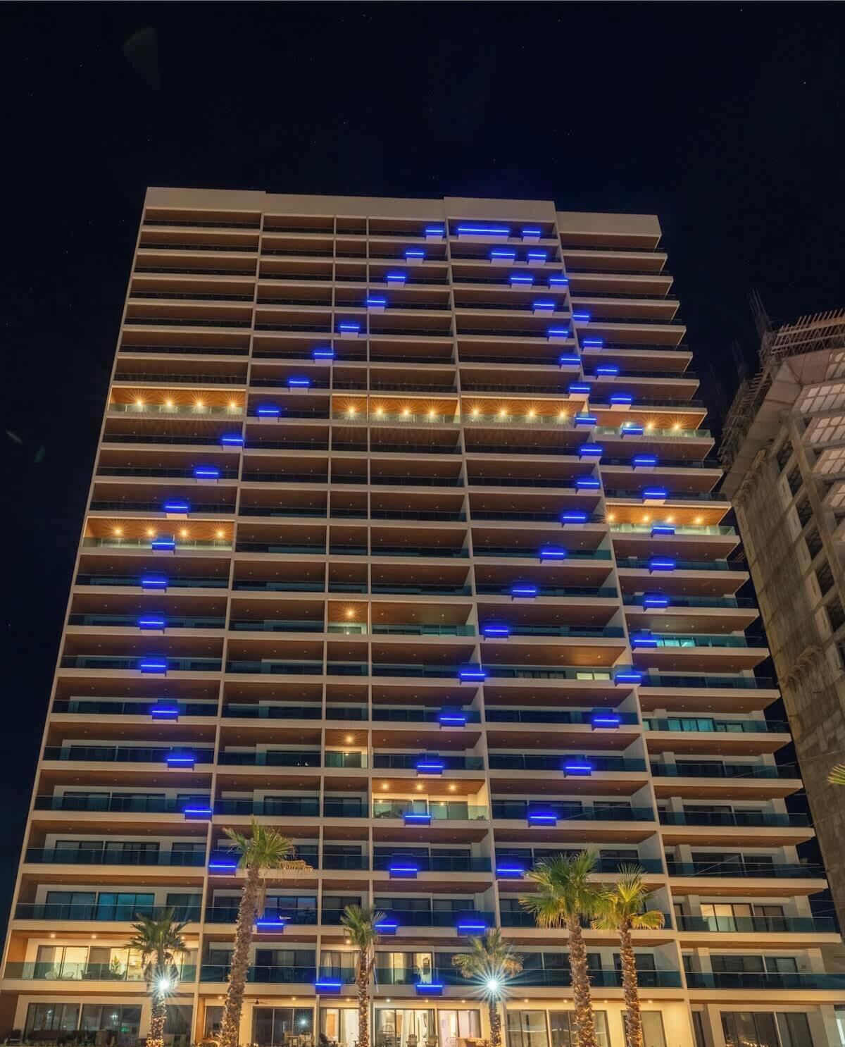 Un hotel moderno a più piani, con balconi e un caratteristico schema di illuminazione sulla facciata.