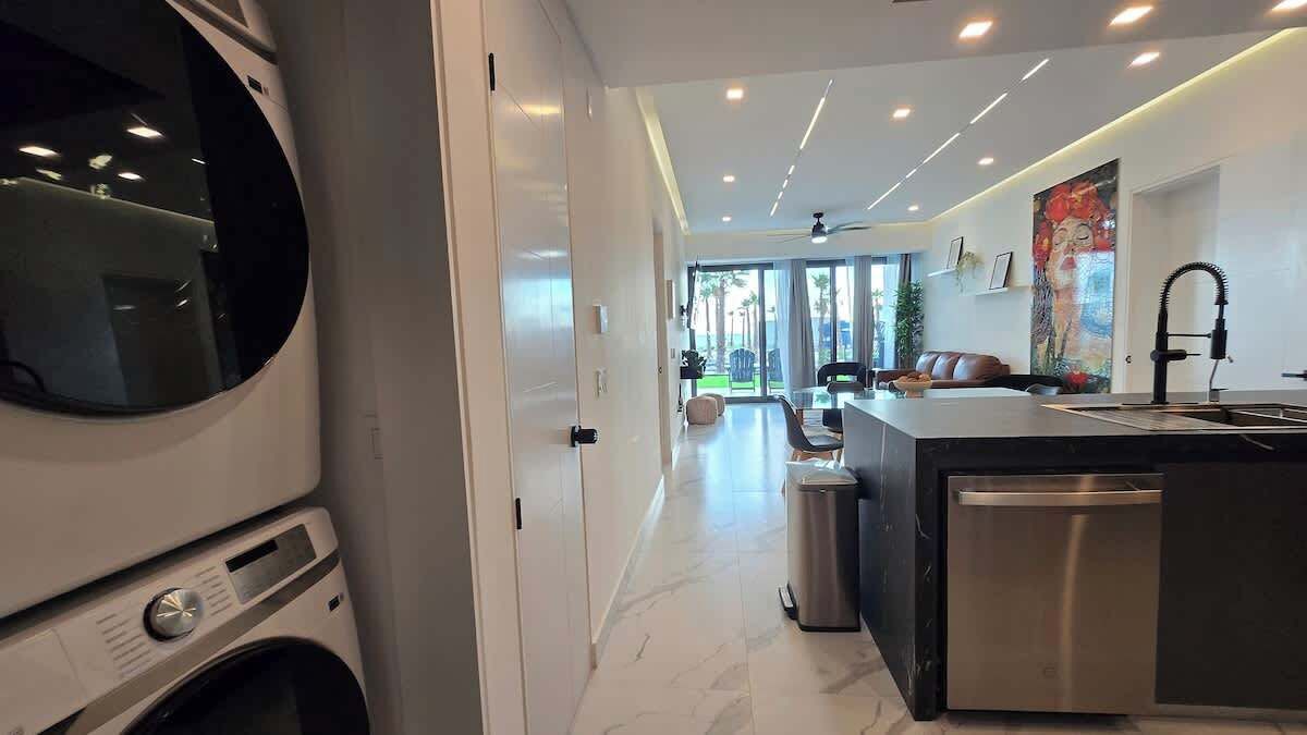 Una cucina moderna con forno integrato, lavello e lavastoviglie.