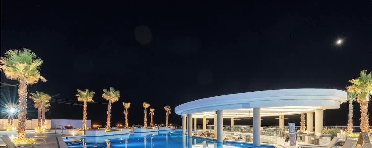 Un espace piscine avec des chaises longues et un coin salon abrité.
