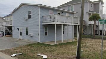 A two-story house with a balcony, a garage, and a visible address sign.