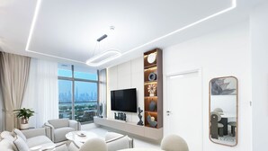 Een moderne hotelkamer met een groot raam, een flatscreen televisie, een zithoek en een decoratieve plank.