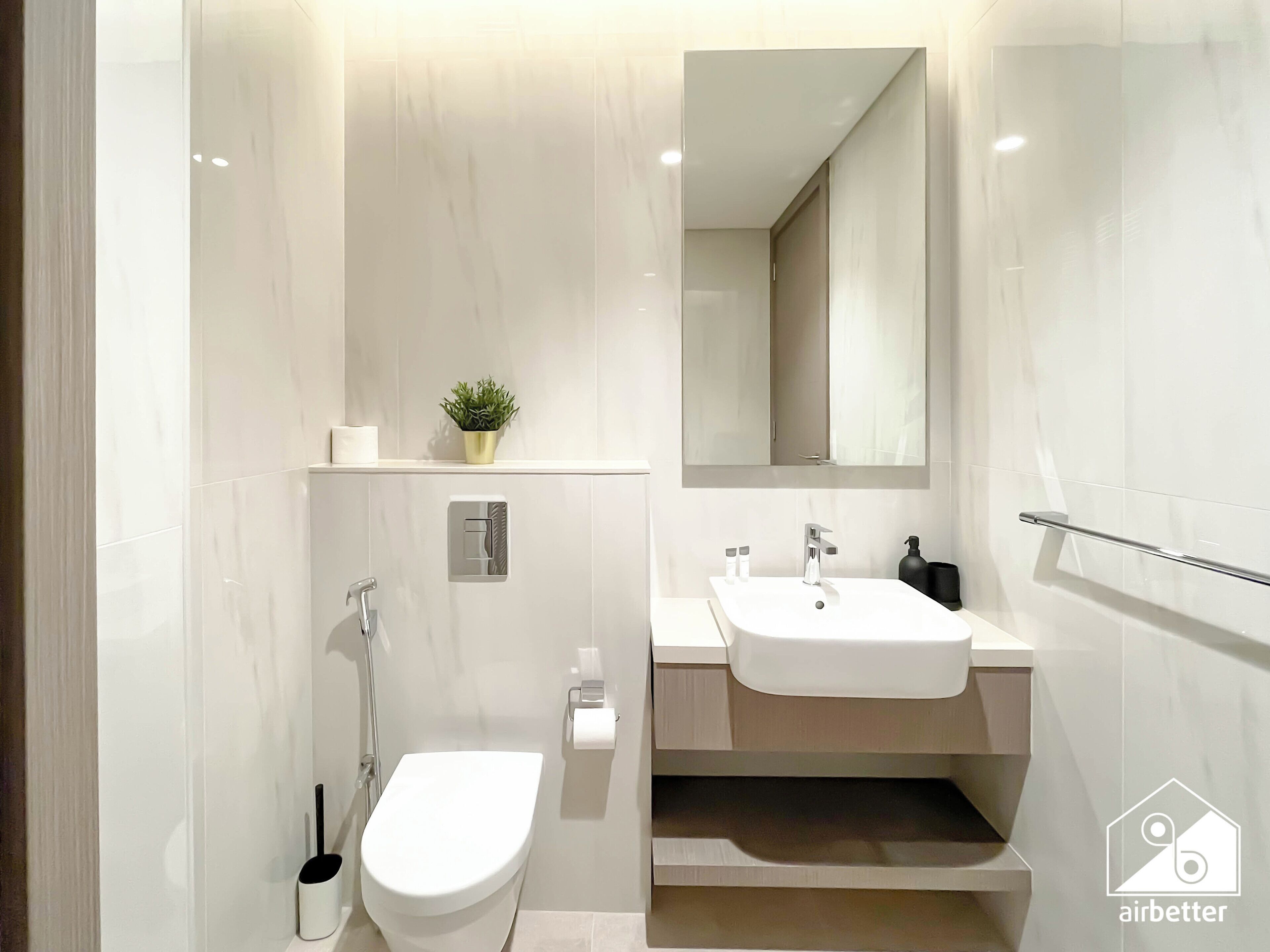 A modern bathroom with a toilet, bidet, and sink.