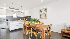 A modern kitchen with white cabinets, a central island, and pendant lighting.