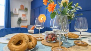 A dining table set with plates, glasses, a candle, and a vase with flowers. - Prime apartment in Leeds - Central location (Leeds)