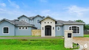 A two-story house with a front entrance, a driveway, and a well-maintained lawn. - Gorgeous 7200 sq ft  estate with AC in vibrant Houston Galleria Area (Houston)