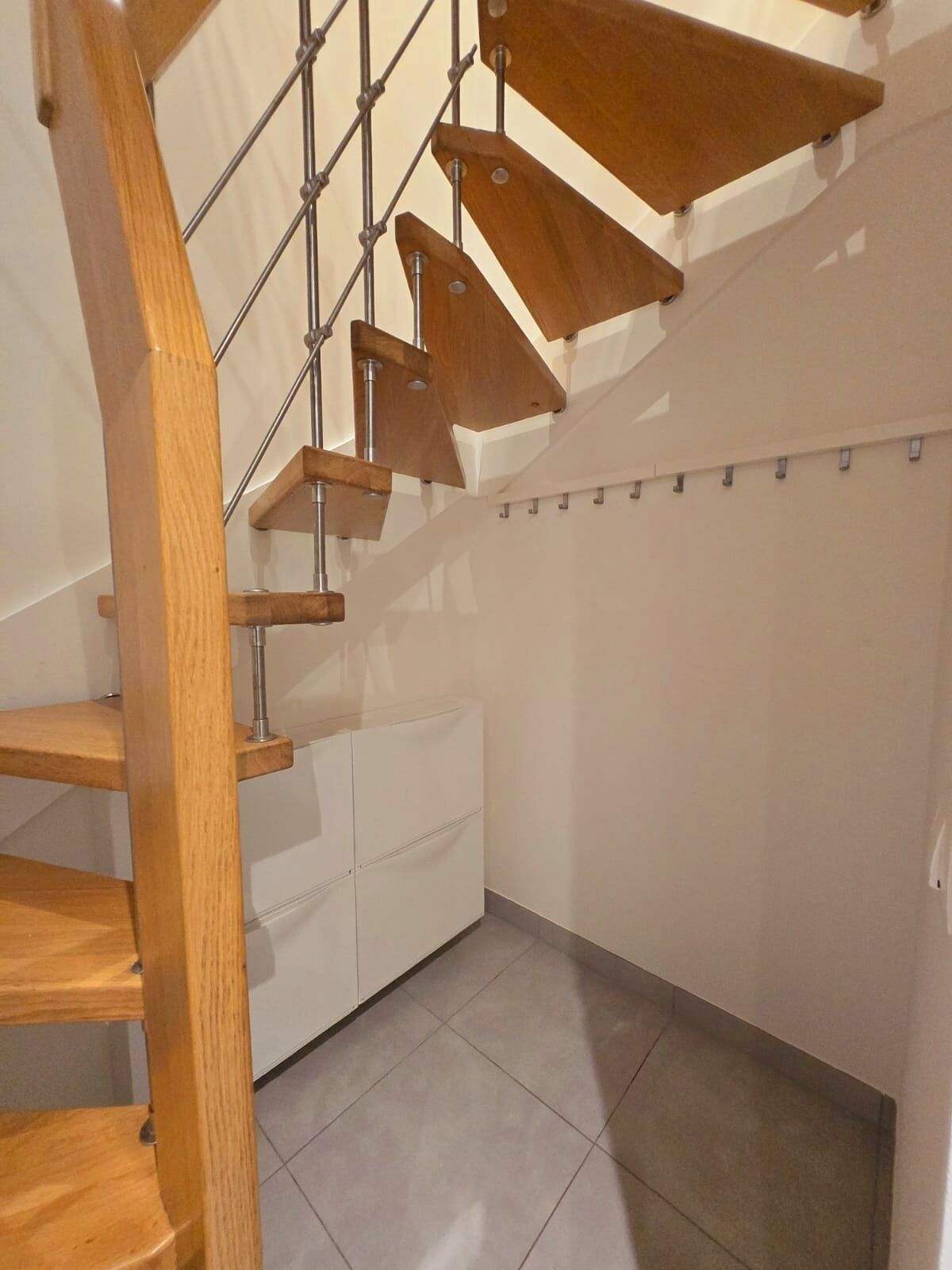 Un escalier moderne avec des marches en bois et des rampes en métal.